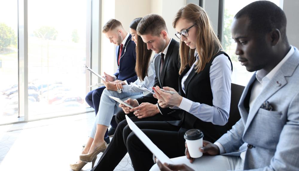 Groupe de personne en tenue de travail, qui attendent pour un entreten d'embauche